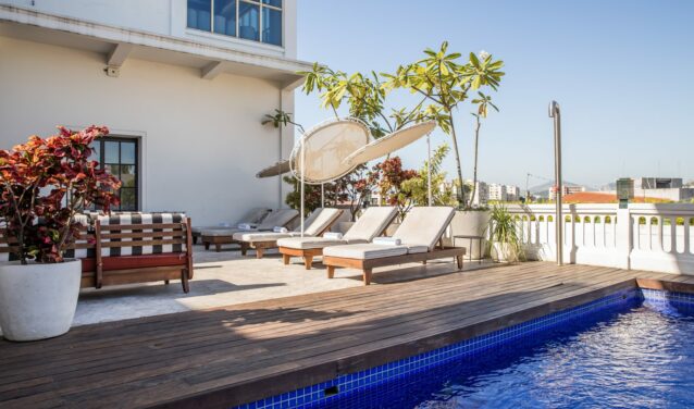 Piscine sur le toit avec vue sur la skyline, chaises longues.