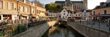 Amiens Glisy : Canal pittoresque avec café et église.