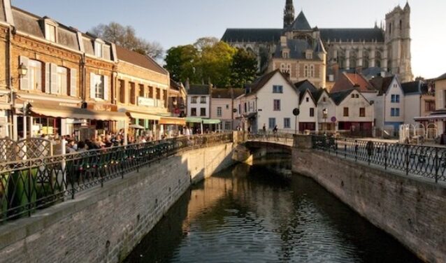 Amiens Glisy : Canal pittoresque avec café et église.