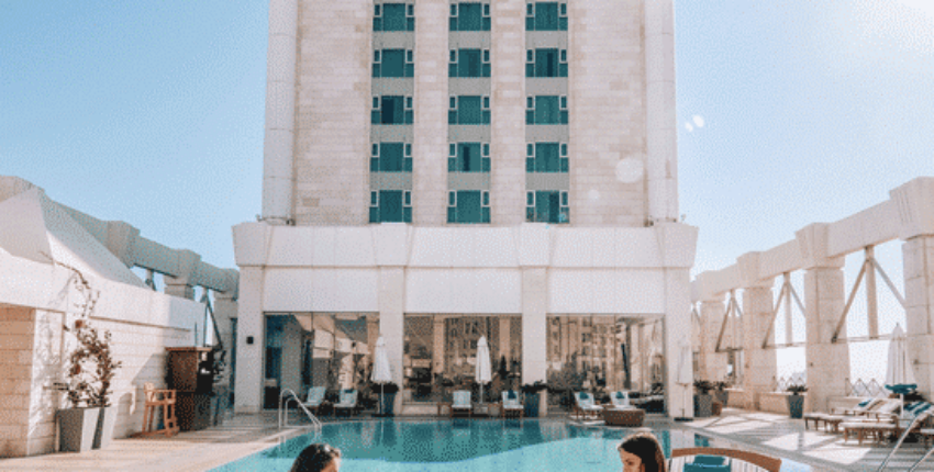 Chaises longues au bord de la piscine devant l'hôtel