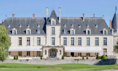 Château D'Augerville, Fontainebleau avec tourelles élégantes et verdure.