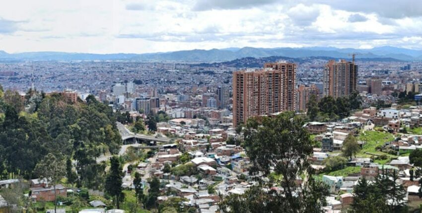 Ville avec vue panoramique sur montagnes et verdure.