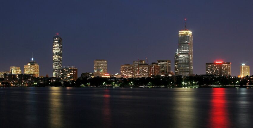 Skyline nocturne ville reflet gratte-ciel sur eau.