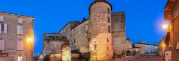 Cognac Châteaubernard fort et tour ronde illuminée au crépuscule.