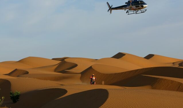 Motocycliste dans le désert près de Dakar, ciel bleu.