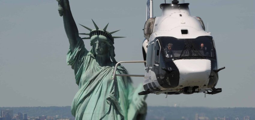 Statue de la Liberté avec hélicoptère en arrière-plan.