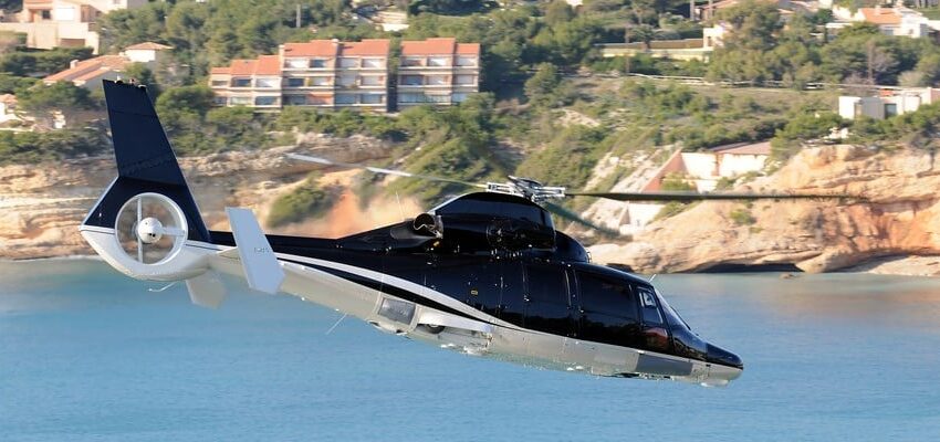 **Texte alternatif :** Un hélicoptère-taxi aérien survolant les falaises côtières