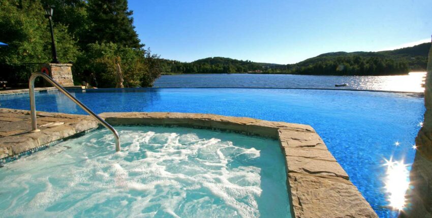 Jacuzzi avec vue sur piscine et lac paisible.