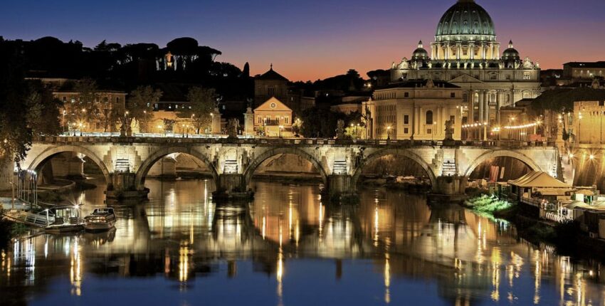 Vacance en Europe : pont illuminé, ciel crépusculaire, rivière.