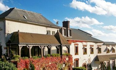 Survol de la Champagne : maison pittoresque entourée de verdure.