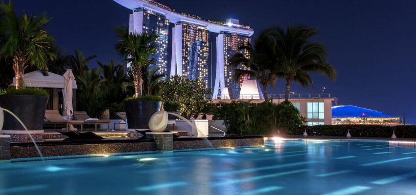 Hôtel luxueux : Piscine à débordement en scène de nuit.
