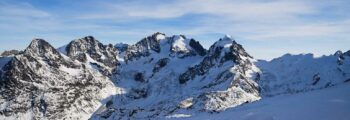 Saint-Moritz - Samedan, montagnes enneigées, ciel bleu clair.