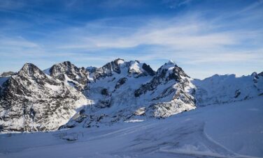 Saint-Moritz - Samedan, montagnes enneigées, ciel bleu clair.