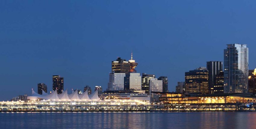 Skyline nocturne avec bâtiments éclairés, structures en voile.