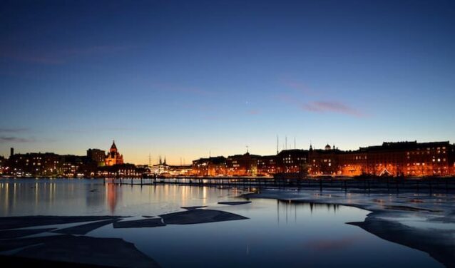 Helsinki crépuscule : Front de mer serein, immeubles illuminés.