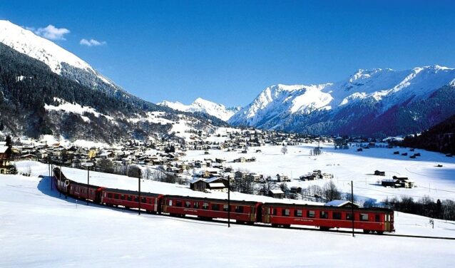 Train rouge, montagnes enneigées, ciel bleu, Klosters.