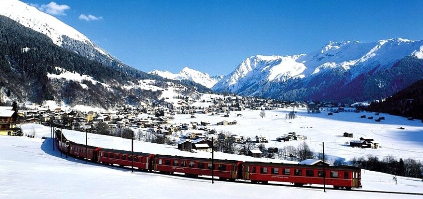 Train rouge, montagnes enneigées, ciel bleu, Klosters.