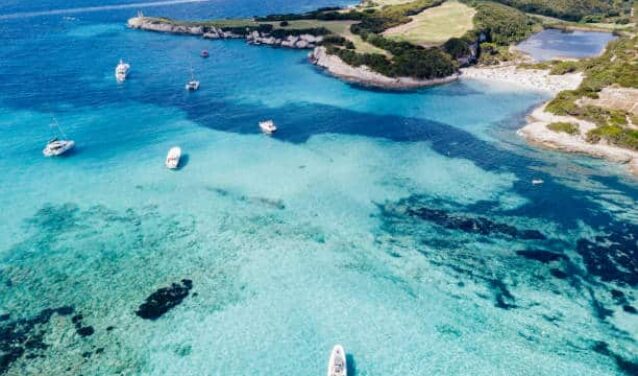 Eau turquoise avec des bateaux, plage en Corse