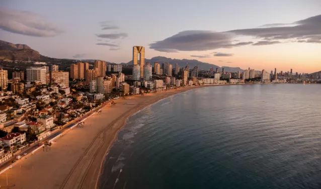 **Alicante Elche au coucher du soleil, la mer au premier plan.**