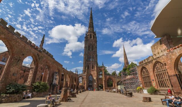 Ruines de la cathédrale de Coventry, ciel bleu, personnes assises.