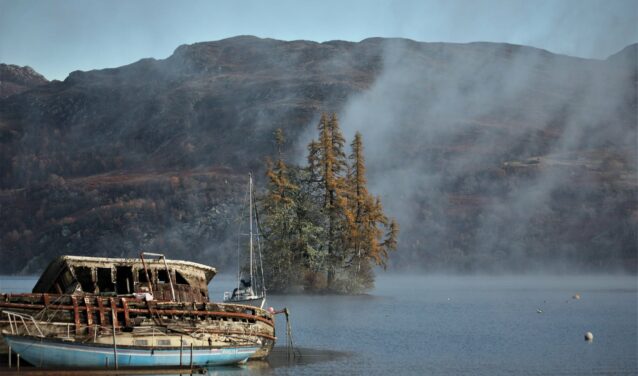 Inverness : bateau abandonné sur lac tranquille.