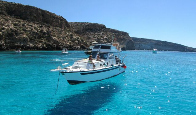 **Location de bateau Lampedusa : Bateau blanc près des falaises**