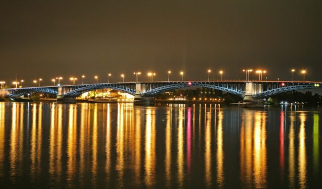 Mayence-Finthen, pont éclairé réfléchissant sur eau calme.