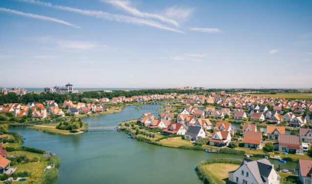 Cadzand quartier résidentiel avec rivière et verdure.