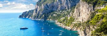 Capri entourée par des bateaux sur mer bleue.