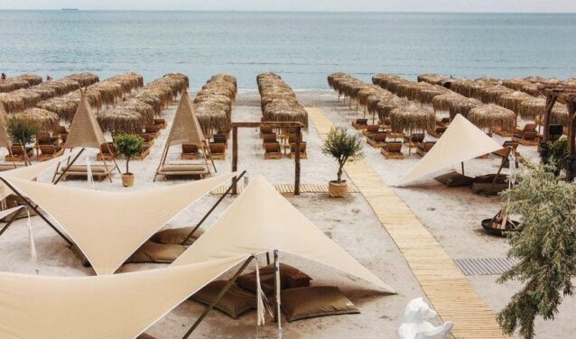 Une plage à Mamaia, des parasols beiges et l'océan.