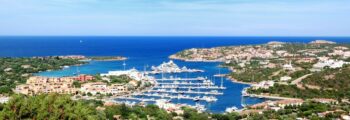 Marina de Porto Cervo, collines vertes et océan en arrière-plan.