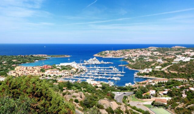 Marina de Porto Cervo, collines vertes et océan en arrière-plan.