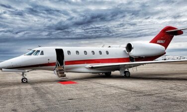 location de jet privé: Jet privé rouge et blanc sur tarmac