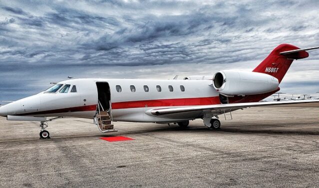 location de jet privé: Jet privé rouge et blanc sur tarmac